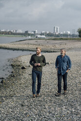 Vater und Sohn machen einen Spaziergang am Rhein und treffen sich zum Gespräch - KNSF02932