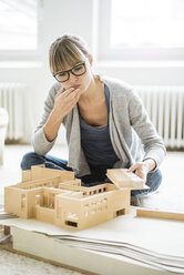 Frau im Büro betrachtet ein Architekturmodell - JOSF01956