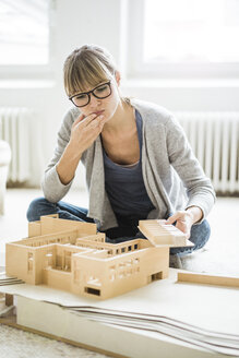 Woman in office looking at architectural model - JOSF01956