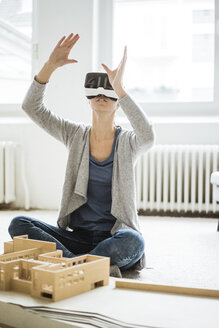 Woman in office with architectural model wearing VR glasses - JOSF01958