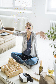 Confetti falling on happy woman in office with architectural model - JOSF01965