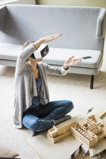 Woman in office with architectural model wearing VR glasses - JOSF01967