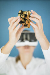 Geschäftsfrau mit VR-Brille hält kubische Struktur - JOSF01977