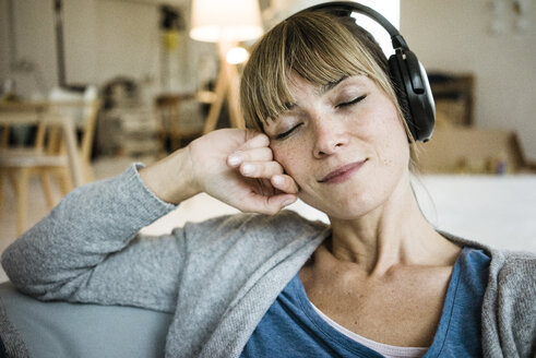 Relaxed woman with closed eyes listening to music with headphones - JOSF02003