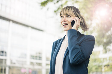 Businesswoman talking on cell phone in the city - JOSF02010