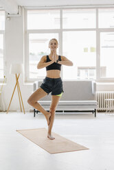 Smiling young woman practising yoga - KNSF02960