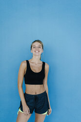 Portrait of smiling young woman in sportswear - KNSF03001
