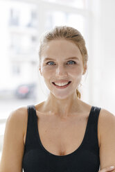Portrait of smiling young woman in sportswear - KNSF03015