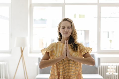 Young woman wearing a dress practising yoga stock photo