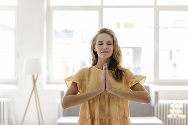 Young woman wearing a dress practising yoga - KNSF03031