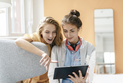 Two young women using tablet stock photo