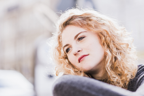 Portrait of daydreaming young woman stock photo