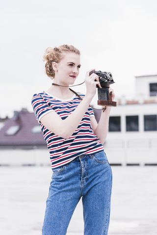 Porträt einer jungen Frau mit alter Kamera, lizenzfreies Stockfoto