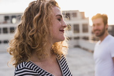 Portrait of happy young woman with eyes closed enjoying sunset - UUF12348