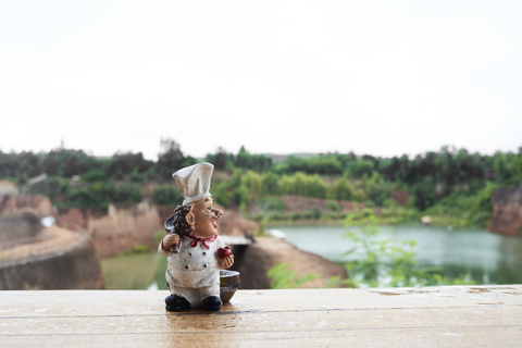 Thailand, Chiang Mai, cook figurine on a wooden table against grand canyon landscape stock photo