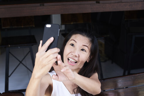 Happy woman taking a selfie with smartphone - IGGF00213