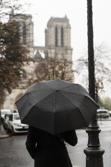 France, Paris, woman with umbrella in front of Notre Dame de Paris - CHPF00452