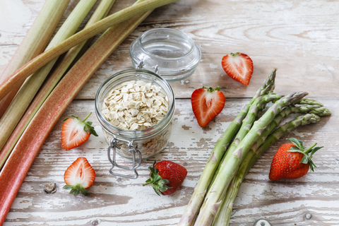 Green asparagus, strawberry, rhubarb and oat flakes stock photo