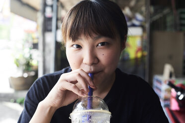 Portrait of woman drinking smoothie - IGGF00217