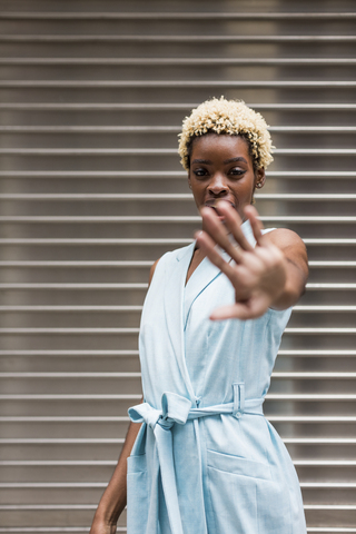 USA, New York, junge blonde afro-amerikanische Frau, hält sich die Hand vor das Gesicht, lizenzfreies Stockfoto