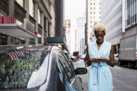 USA, New York, junge blonde afroamerikanische Frau mit Smartphone, lizenzfreies Stockfoto