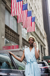 USA, New York, young blonde african-american woman using smartphone - MAUF01253