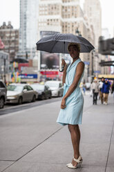 USA, New York, junge blonde afro-amerikanische Frau mit Regenschirm - MAUF01255