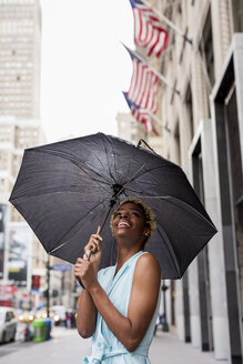 USA, New York, junge blonde afro-amerikanische Frau mit Regenschirm - MAUF01257
