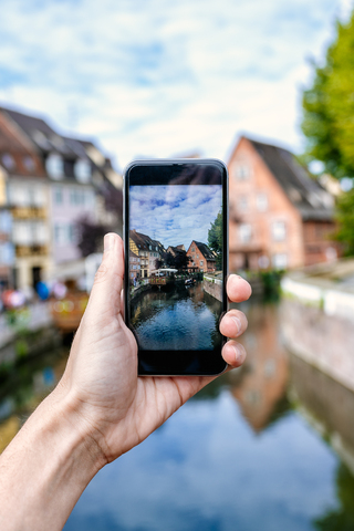 Frankreich, Colmar, Nahaufnahme der Hand eines Mannes, der ein Foto mit seinem Smartphone macht, lizenzfreies Stockfoto