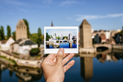 France, Strasbourg,hand holding instant photography of the Strasbourg towers with the same real landscape in the background stock photo