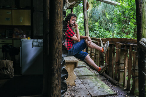 France, Strasbourg, pensive man sitting in old wooden hut - KIJF01730