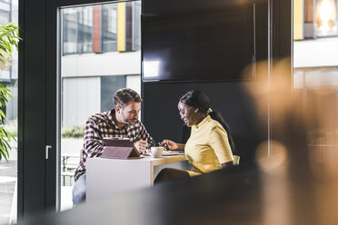 Colleagues working together in a cafe - UUF12371