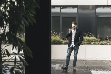 Junger Geschäftsmann nutzt Smartphone außerhalb des Büros - UUF12379