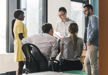 Smiling business people having a meeting in office - UUF12391