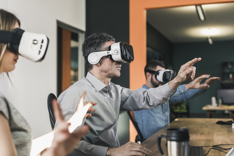 Kollegen tragen VR-Brillen im Büro, lizenzfreies Stockfoto