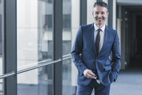 Portrait of smiling businessman on office floor stock photo