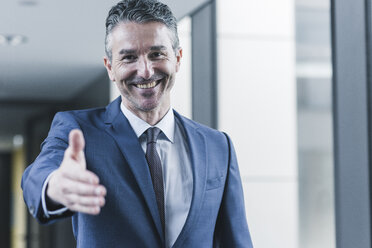 Portrait of smiling businessman about to shake hands - UUF12431