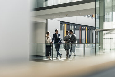 Business people talking on office floor - UUF12433