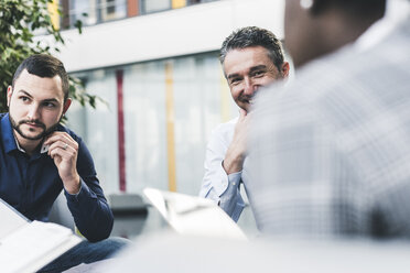 Smiling businessman having a meeting with colleagues - UUF12449