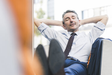 Portrait of businessman relaxing in lounge - UUF12453