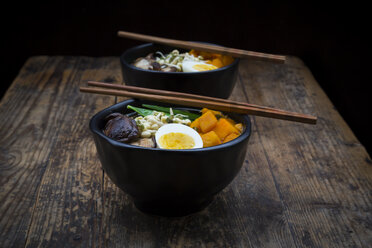 Ramen with noodles, egg, hokkaido pumpkin, mung sprout, shitake mushroom in bowl, chopsticks - LVF06451