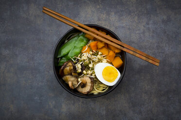 Ramen with noodles, egg, hokkaido pumpkin, mung sprout, shitake mushroom in bowl, chopsticks - LVF06455
