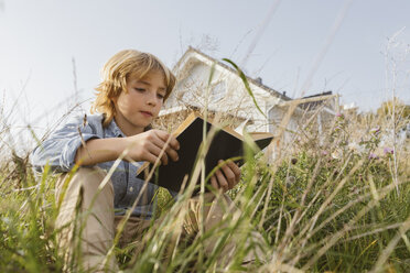 Porträt eines Jungen, der auf einer Wiese sitzt und ein Buch liest - KMKF00066