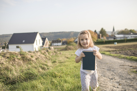 Portrait of blond little girl with a book stock photo