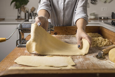 Woman preparing homemade pasta, taking dough - MAUF01263