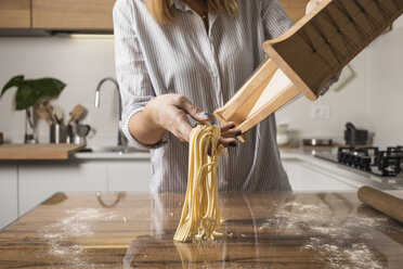 Woman preparing homemade pasta, row noodles, pasta harp - MAUF01264