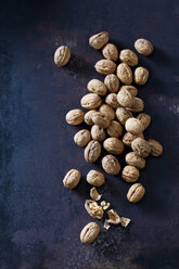 Whole and cracked walnuts on dark metal - CSF28574