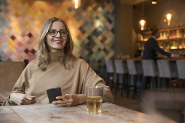 Porträt einer lächelnden Geschäftsfrau in einem Restaurant - SUF00344