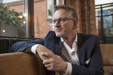 Portrait of content businessman waiting in a restaurant - SUF00353