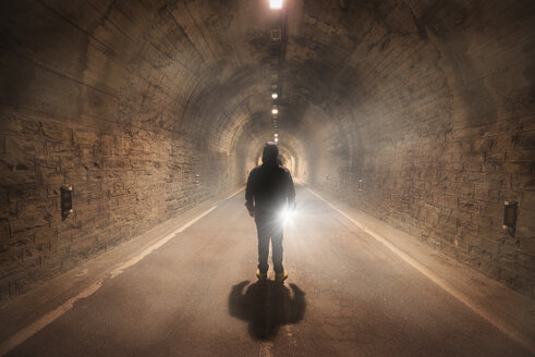 Spanien, Huesca, junger Mann erkundet einen dunklen Tunnel - DHCF00164